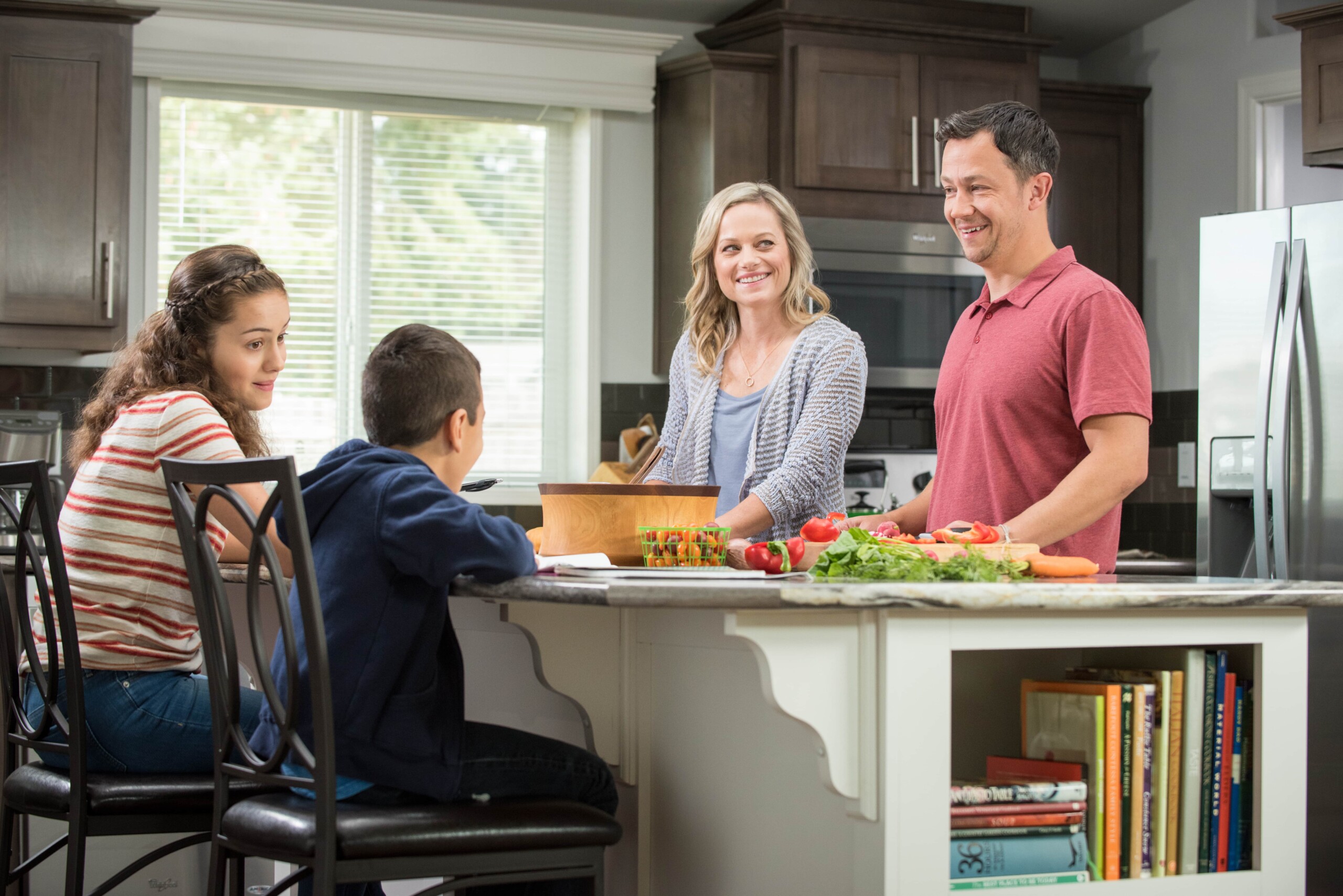 Family in kitchen cooking of a Credit Human Manufactured Home
